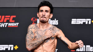 有紋身的UFC拳手在稱重活動中擺姿勢，背景有ESPN和UFC標誌。 — 拳擊 壁紙