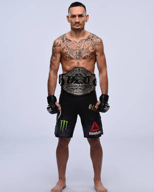 一位有紋身的男性MMA拳手在攝影棚中手持冠軍腰帶。