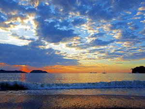 海上夕陽，帆船與拍岸浪花，沙灘 — 雲朵 壁紙