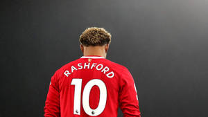 一名身穿印有Rashford名字和號碼10的紅色球衣的足球員的背面視圖。