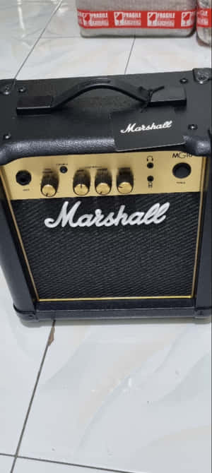 白色瓷磚地板上的黑色Marshall MG10結他擴音器