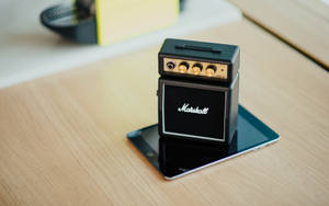 微型Marshall結他擴音器在平板電腦上放在木桌上