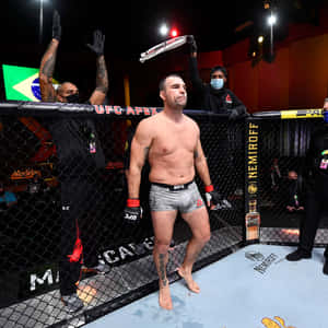 UFC拳手在八角籠中舉臂慶祝勝利。