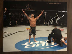 MMA選手在八角籠中高舉雙臂慶祝勝利。