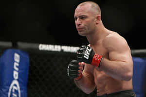 一位赤裸上身的MMA拳手戴著黑色手套站在UFC八角籠內。