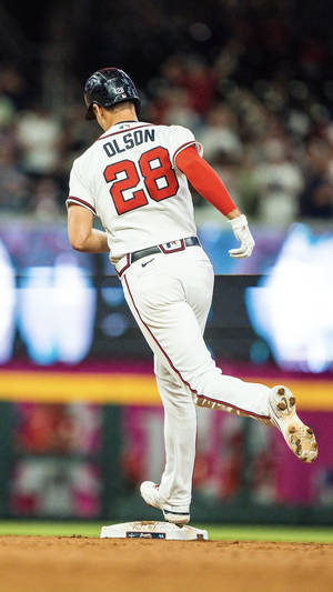 棒球選手奧爾森（28號）夜間在球場跑向壘包。