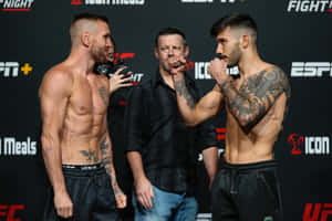 兩名赤裸上身的MMA拳手在帶有ESPN標誌的過磅活動中拳頭相抵。