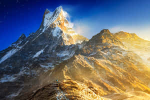 日出時山脊上的一個小小登山者，有積雪的山峰和星空。 — 紅色山脈 壁紙
