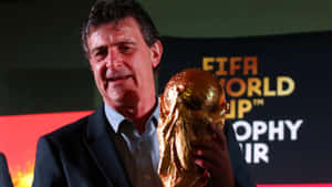 活動中穿西裝的男子手持FIFA世界盃獎盃