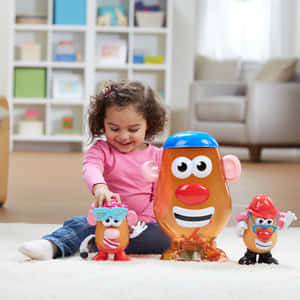 小女孩在白色地毯上玩 Mr Potato Head 玩具時微笑。