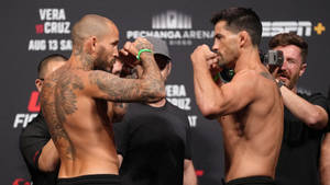 兩名赤裸上身的MMA拳手在緊張的賽前對視中鎖定拳頭。