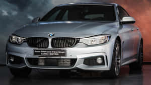 銀色BMW 4系Gran Coupé Iconic Edition在攝影棚中，帶有戲劇性燈光。