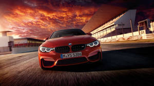 紅色BMW M4在日落時分的賽道上疾馳。