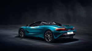 在攝影棚中，戲劇性燈光下的藍綠色McLaren 720S Spider開篷跑車。