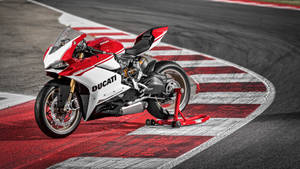 紅白相間的Ducati電單車在賽道上，帶有紅白相間的賽道邊緣。