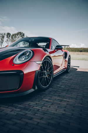 白天鵝卵石路上的紅色保時捷911 GT2 RS。 — Huawei MatePad Air (2026) 壁紙