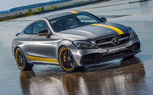 銀色 Mercedes-AMG C63 Coupe 在潮濕賽道上帶有黃色點綴