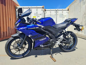 藍色Yamaha R15運動電單車泊喺室外貨櫃附近。 — 4:3 壁紙