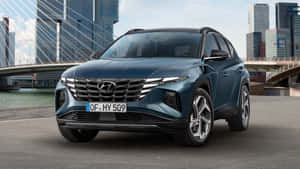 藍色現代 Tucson SUV 停泊在都市橋樑和高樓附近。