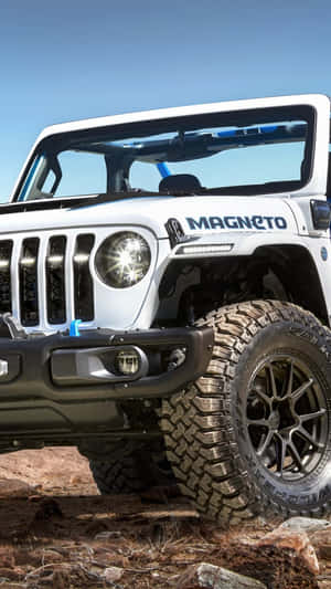 藍天下岩石沙漠地形上的白色Jeep Wrangler Magneto