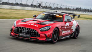 紅色 Mercedes-AMG GT 安全車在賽道上奔馳，呈現動態模糊效果。