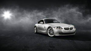 銀色BMW跑車在煙霧瀰漫的黑暗工作室中被聚光燈照亮。