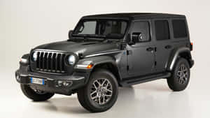 啞光黑色Jeep Wrangler SUV在工作室中，配有合金輪圈和潔白背景。