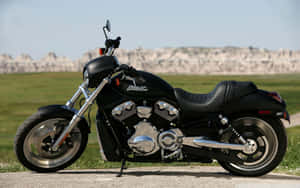 黑色Harley-Davidson電單車停泊在道路上，背景有草地平原和岩石地貌。