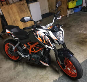 橙色和黑色KTM Duke電單車停放在車庫內。 — 機車 壁紙