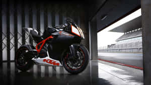 黑色和橙色KTM RC8R電單車停放在車庫，外面有賽道。