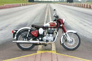 復古紅色 Royal Enfield 電單車停在賽車場起跑線上。