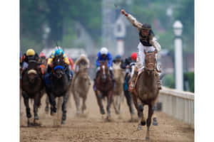 騎師在泥地賽道上於獲勝馬上高舉手臂慶祝勝利。