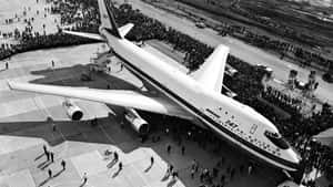 人群聚集在停機坪上一架巨大的波音747飛機周圍。