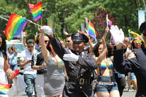 警察在Pride遊行中揮舞彩虹旗，微笑的人群。 — 驕傲 GIF 壁紙