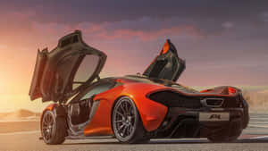 橙色McLaren P1超級跑車，鷗翼車門打開，停在夕陽下的賽道上。 — 麥拿侖 GIF 壁紙