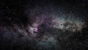 銀河系中充滿活力的紫色和藍綠色星雲，以及夜空中無數的星星。