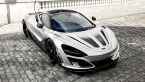 銀色McLaren跑車停在石牆附近的鵝卵石街道上。