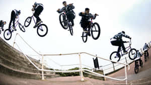 BMX車手在混凝土樓梯欄杆上空進行空中花式動作。