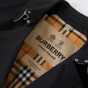 海軍藍色 Burberry 風衣，帶有格紋襯裡和可見的品牌標籤。