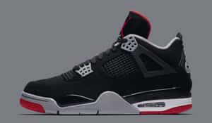 黑色 Jordan 4 運動鞋，帶有紅色和銀色點綴，在灰色背景上。