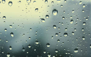 玻璃上的雨滴，背景為模糊的天空