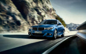 藍色BMW雙門跑車在模糊景色的山路上疾馳。