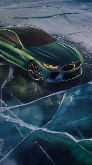 綠色BMW M8 Coupe在裂冰上，發光車頭燈映照水中。