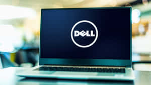 銀色手提電腦在辦公室環境中顯示Dell標誌