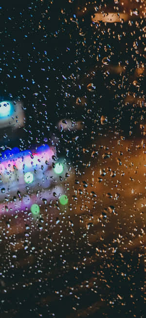 窗戶上的雨滴，夜晚模糊的城市燈光閃爍。
