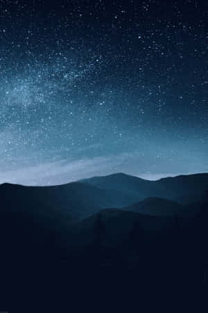 在星空下，剪影般的山脈，銀河可見。