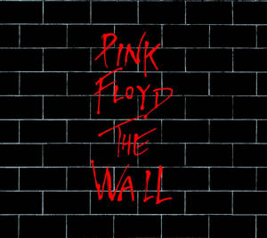 黑色磚牆上的紅色手寫文字寫著 Pink Floyd The Wall。