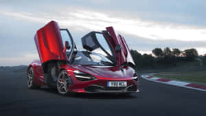 紅色McLaren跑車在賽道上打開鷗翼車門，時值黃昏。