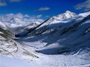 積雪的山口，蜿蜒的道路，藍天白雲 — 冬日美學 壁紙