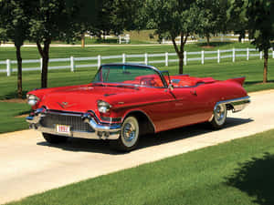 紅色1957年凱迪拉克敞篷車停在陽光明媚的日子裡，靠近白色柵欄和綠色草坪。